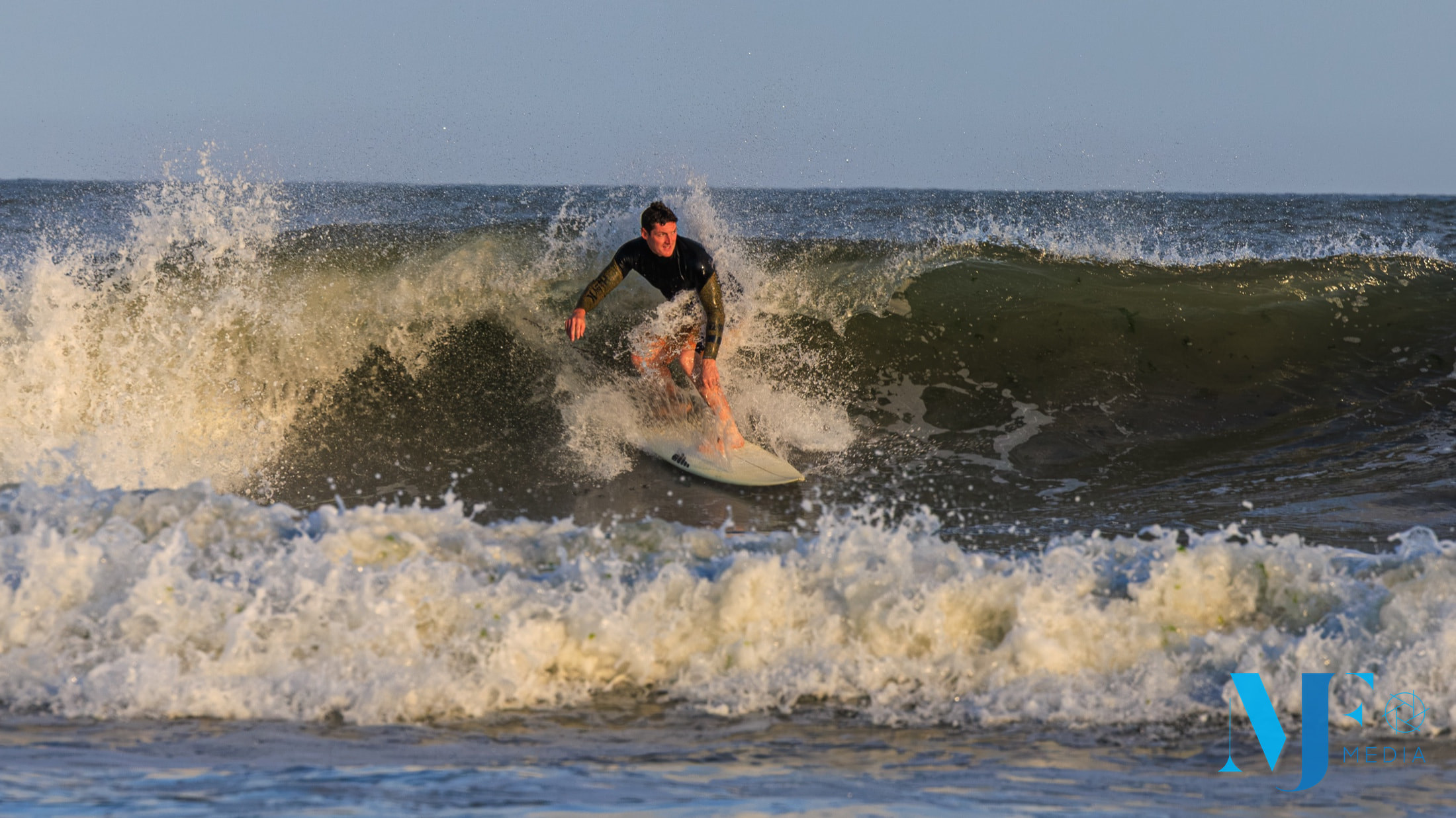 Surfer driving through a breaking Rockaway wave